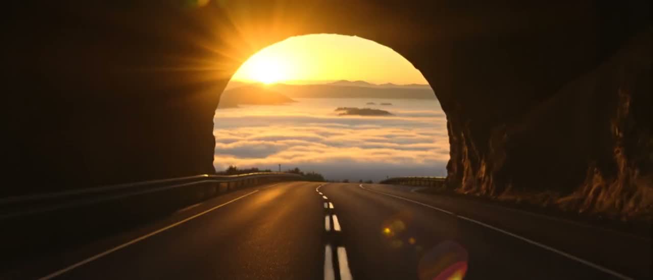 An arch of high ground above the clouds, seen at altitude.